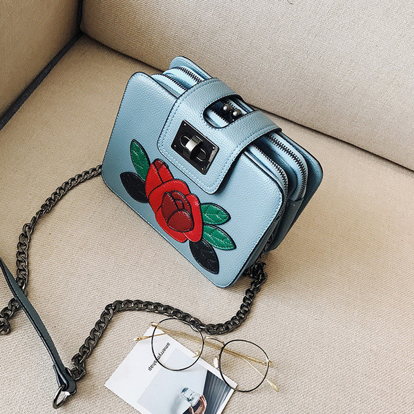 Modern női táska fém hosszú füllel és virág emblémával