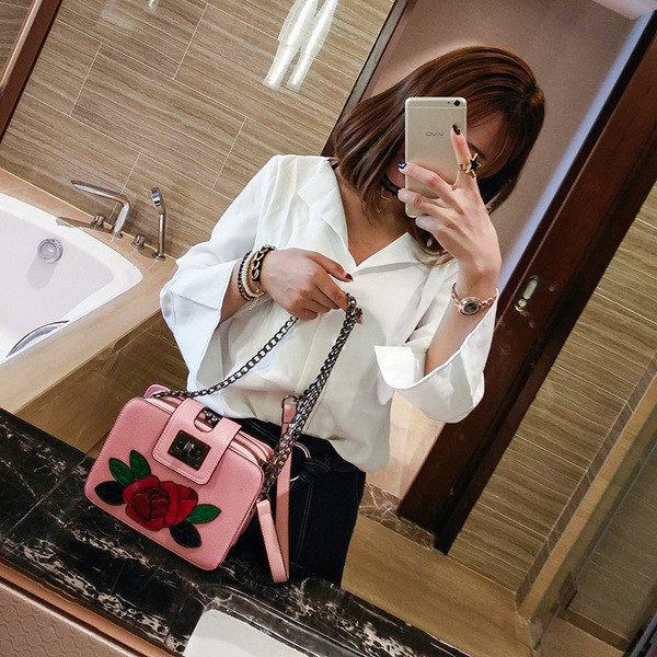 Modern női táska fém hosszú füllel és virág emblémával