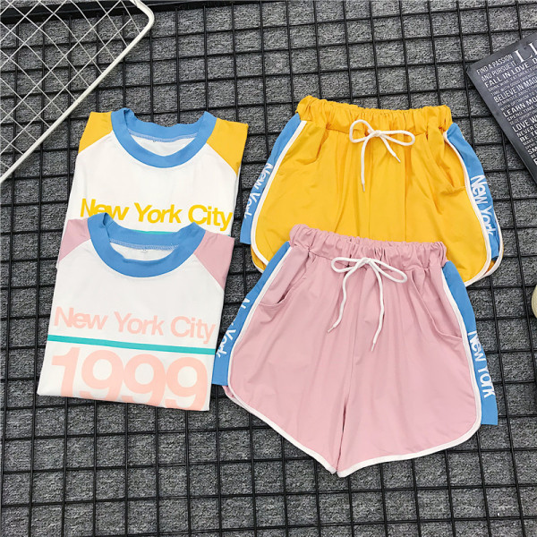 Set sport pentru femei care include un tricou cu inscripție și pantaloni scurți