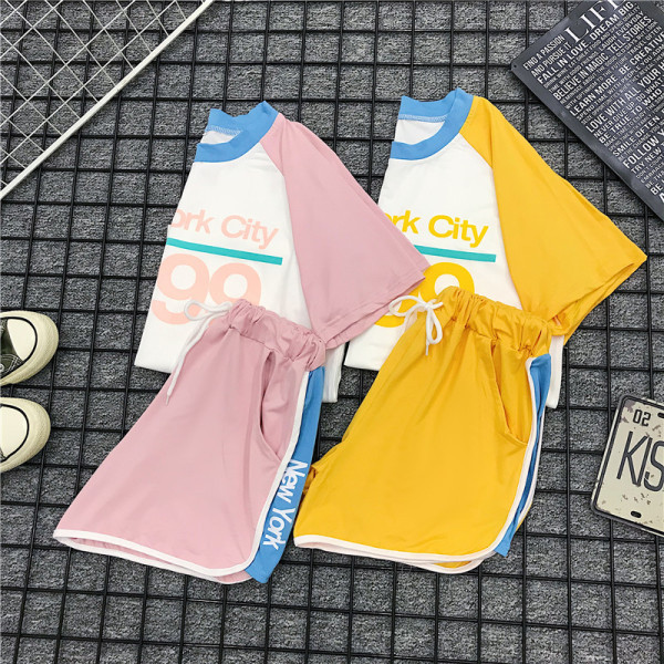 Set sport pentru femei care include un tricou cu inscripție și pantaloni scurți