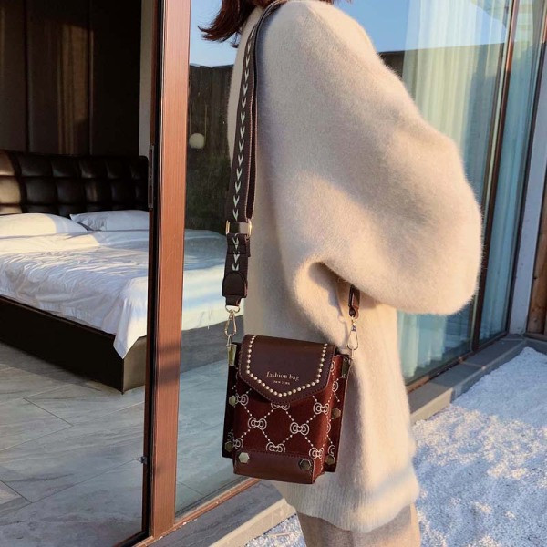 Moodne metallelementide ja pika sangaga naistekott