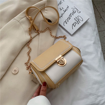 Κομψή γυναικεία τσάντα με μεταλλικά στοιχεία και μακριά λαβή