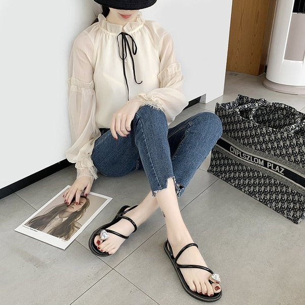 Sandale de damă între vârf și un element de piatră