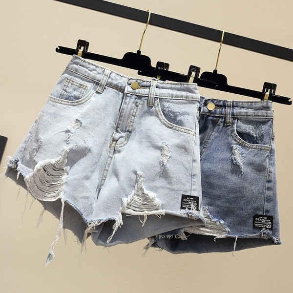 Naiste lühikesed teksad embleemi ja rebenenud motiividega