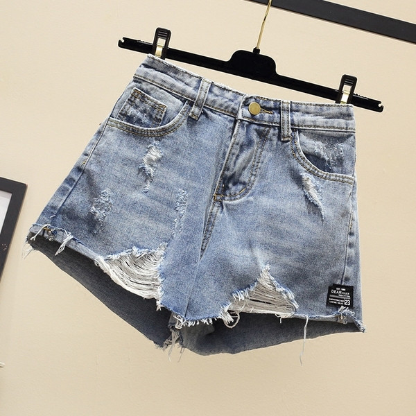 Naiste lühikesed teksad embleemi ja rebenenud motiividega