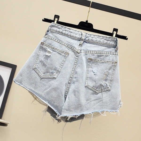 Naiste lühikesed teksad embleemi ja rebenenud motiividega