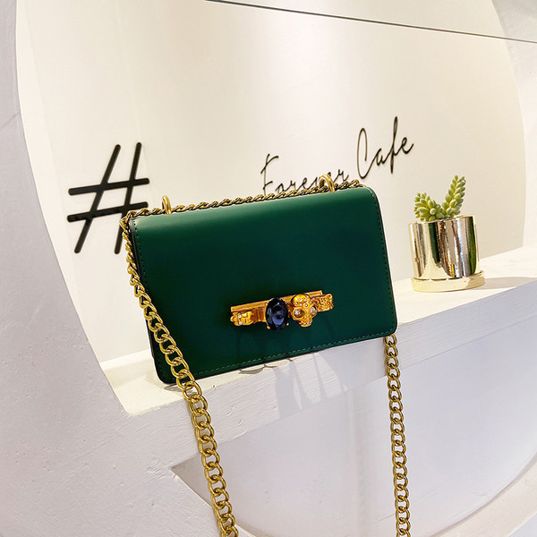 Sieviešu soma ar metāla elementiem un garu rokturi