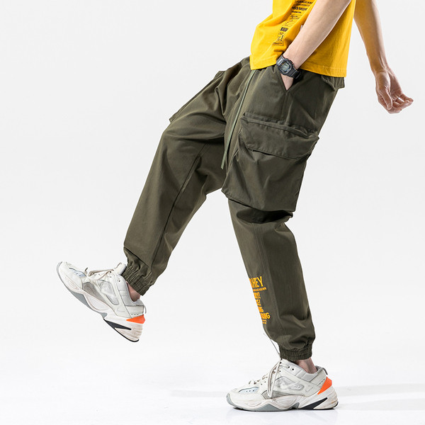 Modernas vīriešu bikses ar lielām kabatām un uzrakstu