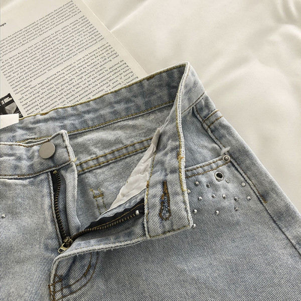 Mūsdienīgi īsi džinsi ar cilpām un saplēstiem motīviem