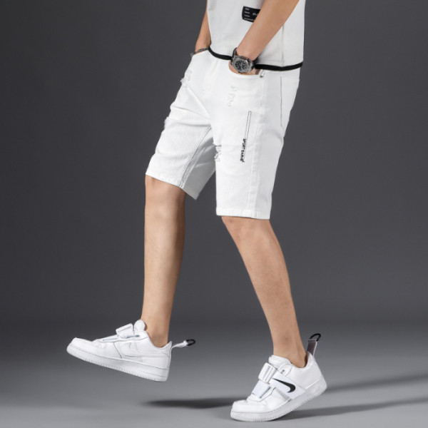 Valged lühikesed vabaaja teksad, millel on rebenenud motiivid