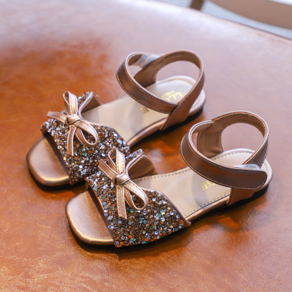 Gyerek hétköznapi szandál szalaggal és fényes hatással