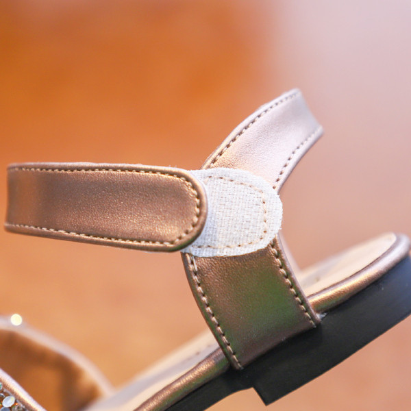 Gyerek hétköznapi szandál szalaggal és fényes hatással