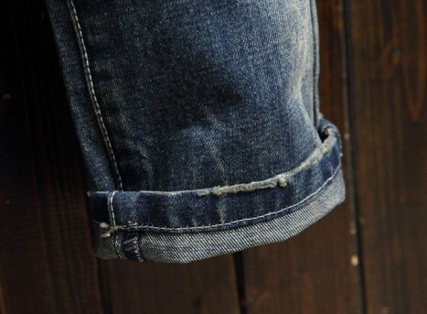 Modern férfi hosszú farmernadrág szakadt motívumokkal és zsebekkel