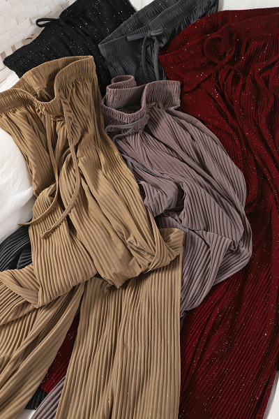 Plisētas sieviešu bikses un spīdīgas daļiņas