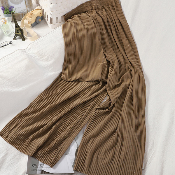 Plisētas sieviešu bikses un spīdīgas daļiņas