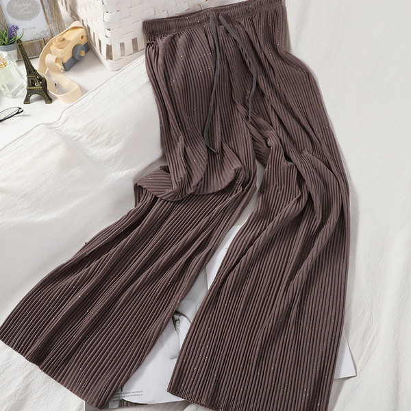 Plisētas sieviešu bikses un spīdīgas daļiņas