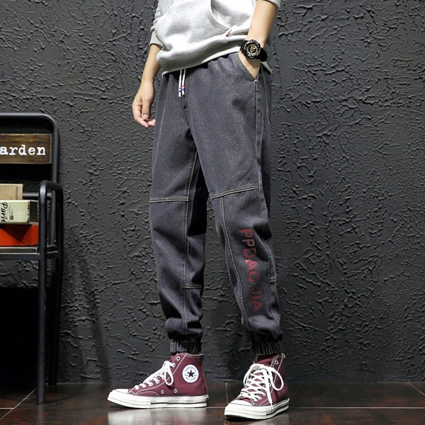 Modern férfi hosszú farmernadrág felirattal és fűzővel