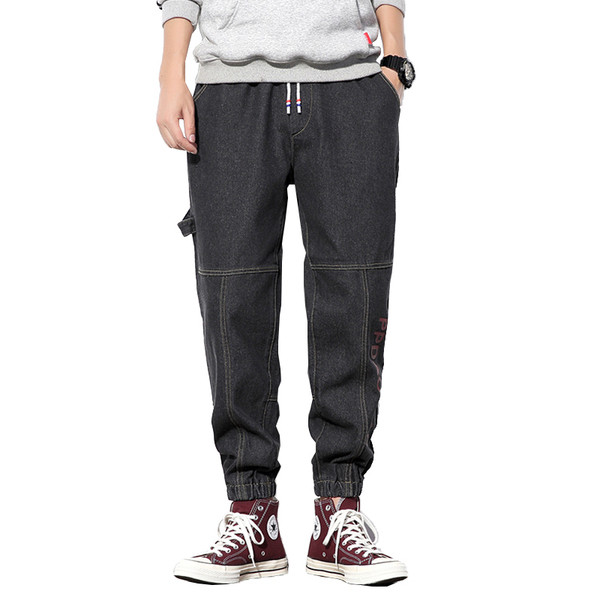 Modern férfi hosszú farmernadrág felirattal és fűzővel