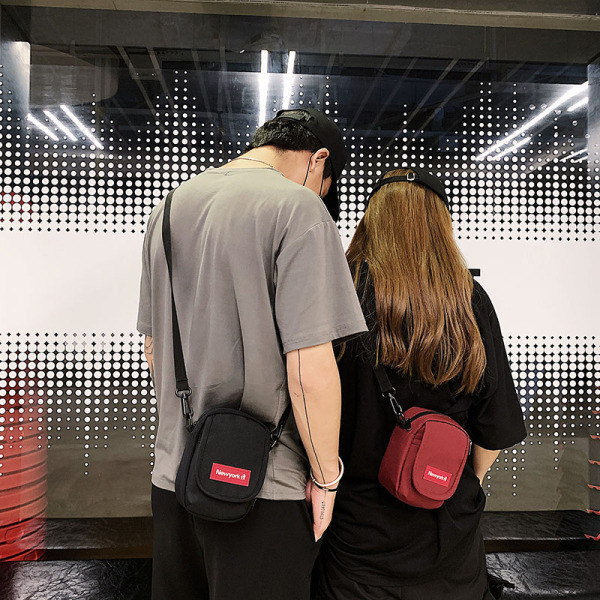 Kisméretű férfi táska emblémával és hosszú füllel