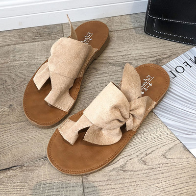 Modern női papucs lapos talppal, dekoratív csomóval