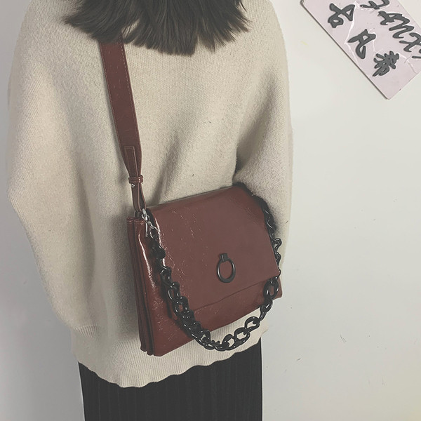 Elegantna ženska torba od eko kože kvadratnog oblika i kratke metalne ručke