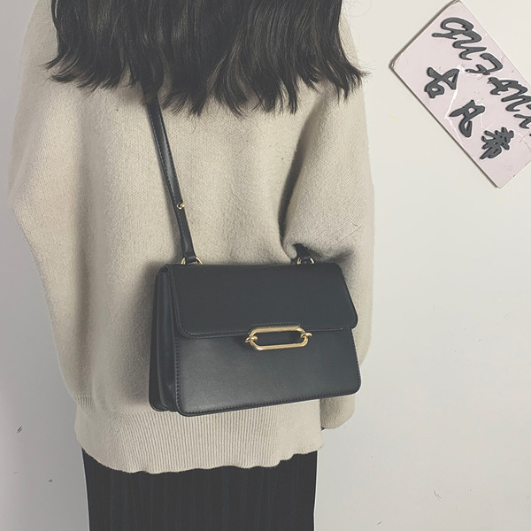 Női bőrtáska hosszú füllel, fém elemmel