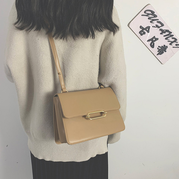 Női bőrtáska hosszú füllel, fém elemmel