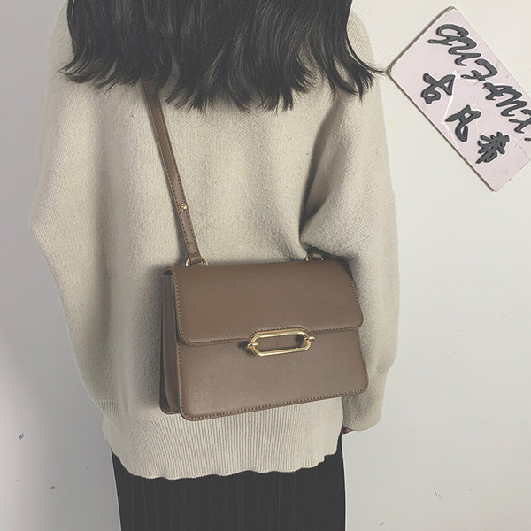 Női bőrtáska hosszú füllel, fém elemmel