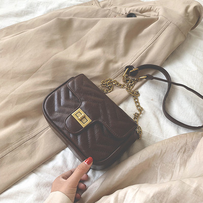 Női bőrtáska hosszú fém fogantyúval