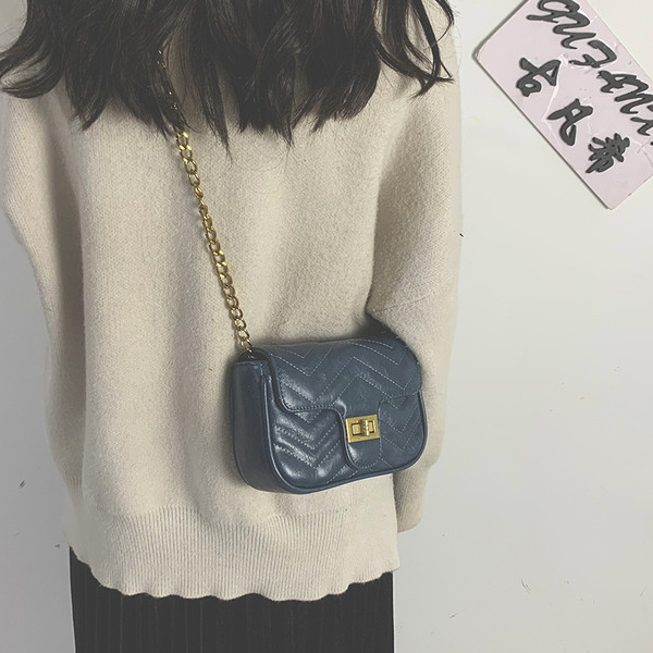 Női bőrtáska hosszú fém fogantyúval