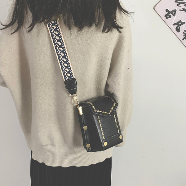 Női bőrtáska széles, színes fogantyúval