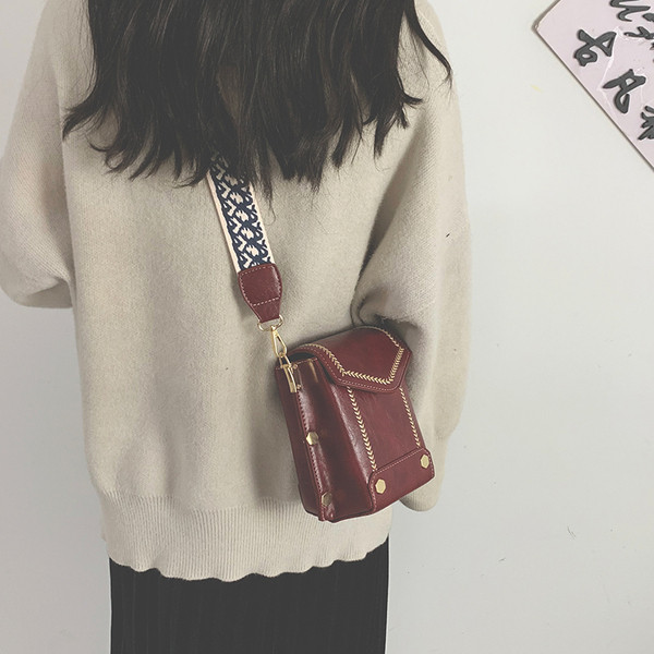 Női bőrtáska széles, színes fogantyúval