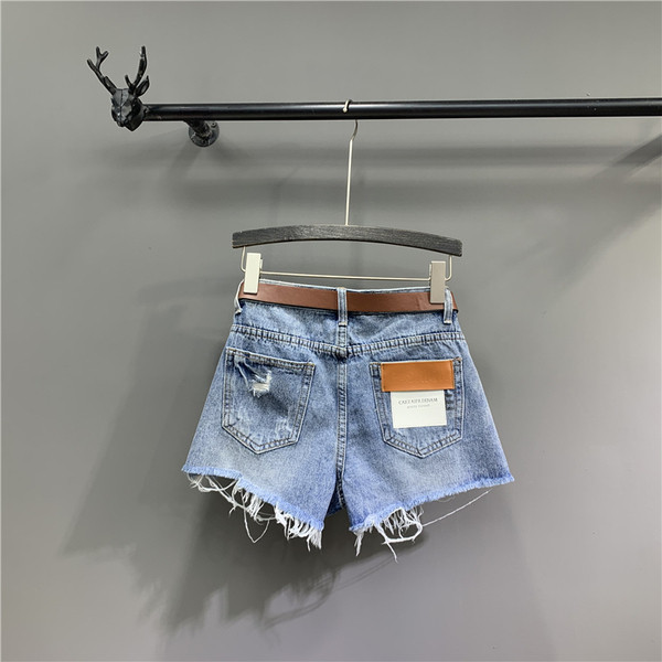 Alkalmi női farmer rövidnadrág övvel, szakadt elemekkel