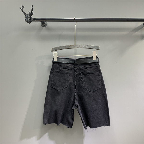 Női farmer övvel, szakadt motívumokkal