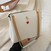 Női bőrtáska fém fogantyúval és kiegészítővel