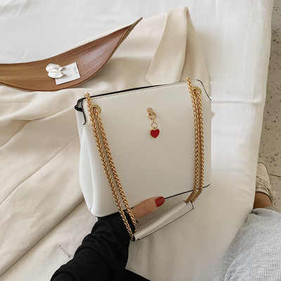 Női bőrtáska fém fogantyúval és kiegészítővel