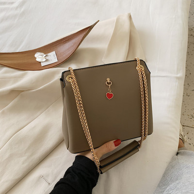 Női bőrtáska fém fogantyúval és kiegészítővel