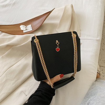 Női bőrtáska fém fogantyúval és kiegészítővel