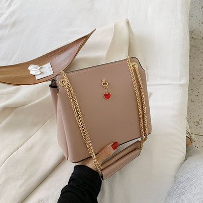 Női bőrtáska fém fogantyúval és kiegészítővel