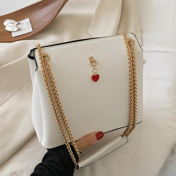 Női bőrtáska fém fogantyúval és kiegészítővel