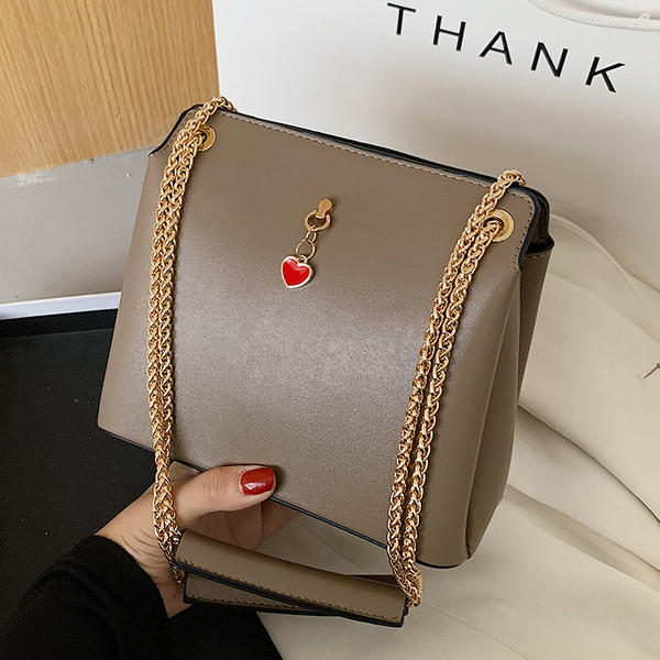 Női bőrtáska fém fogantyúval és kiegészítővel