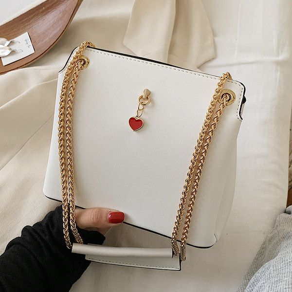 Női bőrtáska fém fogantyúval és kiegészítővel