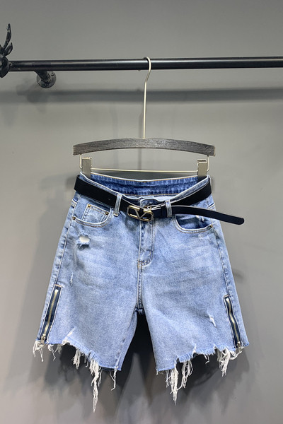 Alkalmi női farmer övvel, cipzárral és szakadt elemekkel