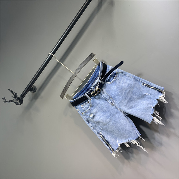 Alkalmi női farmer övvel, cipzárral és szakadt elemekkel