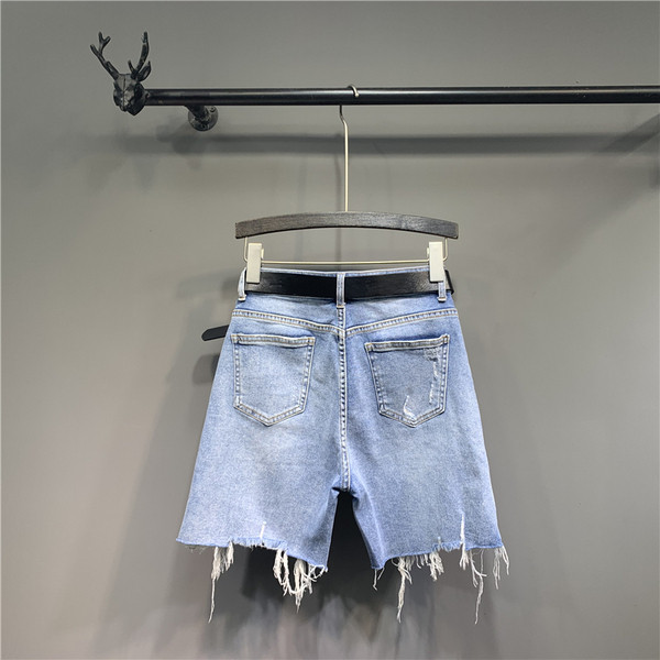 Alkalmi női farmer övvel, cipzárral és szakadt elemekkel