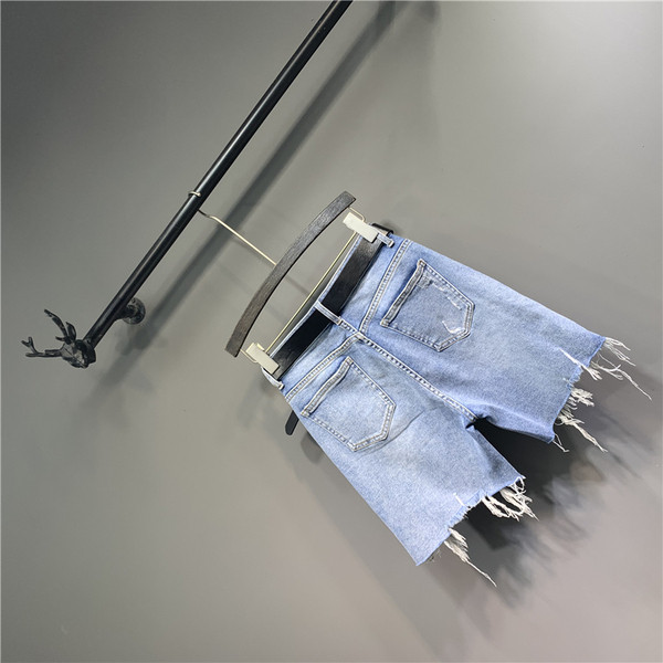 Alkalmi női farmer övvel, cipzárral és szakadt elemekkel