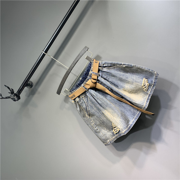 Női farmer övvel, szakadt elemekkel