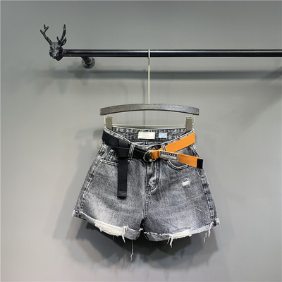 Modern női rövid farmernadrág övvel, szakadt motívumokkal