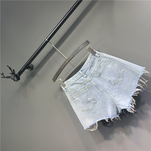 Női rövid farmer gyöngyökkel és szakadt elemekkel, kék színben