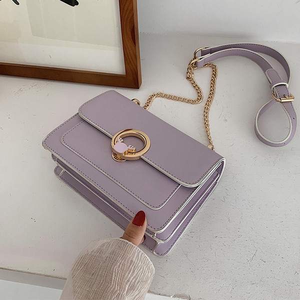 Elegantna ženska torba s dugom ručkom i metalnim ukrasom